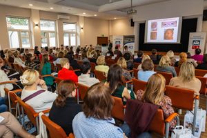 Konferencja z prezentacją, uczestnicy w sali.