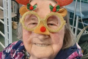 Starsza kobieta w zabawnych okularach renifera.