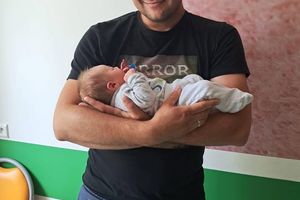 Mężczyzna przytulający niemowlę.